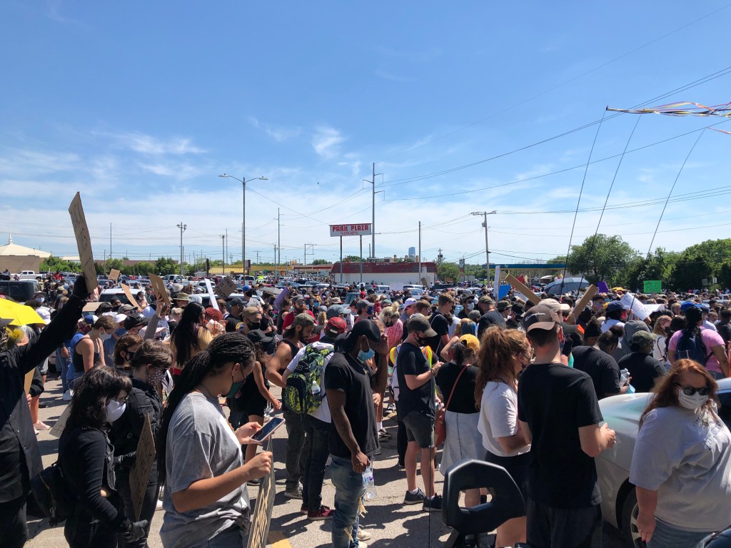 Protesters at an Oklahoma City rally protesting the death of George Floyd listen to speakers in front of a downtown Oklahoma City store.